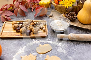 Cooking cookies in the form of leaves on the kitchen table with autumn decor.