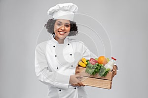 happy smiling female chef with food in wooden box