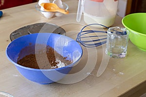 Cooking a dessert. The ingredients on the table, flour, sugar, kitchen scales, eggs, cacao, mixer. Homemade food and sweets.