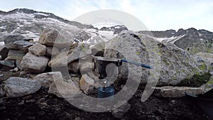 Cooking device with amazing Aneto`s mountain landscape on background, recorded form the inside of a tent in the Spanish Pyrenees.