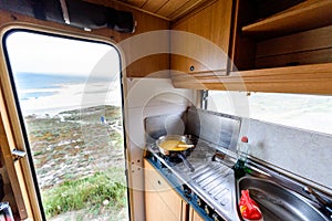 Cooking dinner or breakfast in camper RV with beach view
