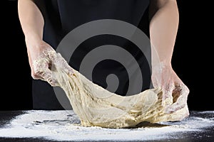 Cooking dough with female hands. An experienced chef in a professional kitchen prepares dough with flour