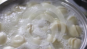 Cooking dumplings in a saucepan. Dumplings are cooked in boiling water, there is steam