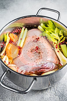 Cooking of Eisbein from Raw pork Hock ham, shank with vegetables and herbs. White background. Top view