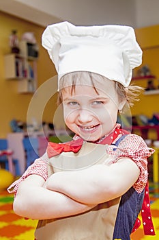 Cooking fever. Humorous portrait of cute child girl chef.