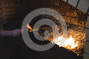 Cooking on fire in a restaurant. Cook inflates the coals. flying sparks