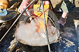 Cooking fish soup in the stowed bowler over campfire