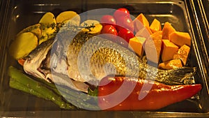 Cooking fish and vegetables in baking oven
