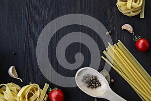 Cooking food background with free space for text. Composition with spaghetti, tomato, eggs, garlic, bay leaf over the wood