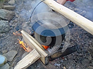 Cooking food in a cauldron on fire, natural conditions