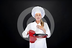 Cooking and food concept - female chef over dark backgro photo
