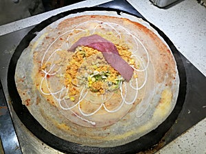 Cooking france savory crepe with bacon, sweet corn, egg and salad top with mayo on the hot stove