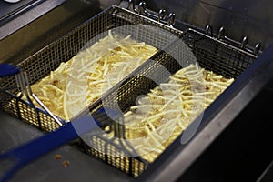 Cooking french fries. Close up of Frying french fries in the fryer in hot oil