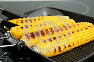 Cooking fresh corn cobs on grill pan