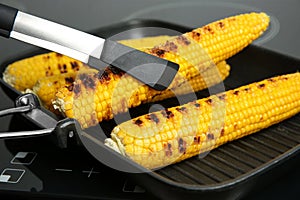 Cooking fresh corn cobs on grill pan
