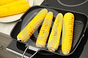 Cooking fresh corn cobs on grill pan
