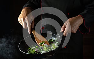 Cooking fresh vegetables in a frying pan by a chef for a vegetarian diet. Place to advertise a hotel or restaurant. Vegan food
