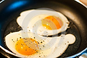 Cooking fried eggs with a liquid yolk in a pan in sunflower oil