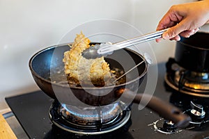Cooking fried Japanese pork Tonkatsu homemade cutlet, handle pork by pinch and using temperature tool during cook on heat oil on p