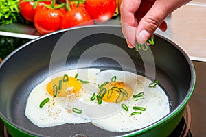cooking fried scrambled eggs, hands with a wooden spatula