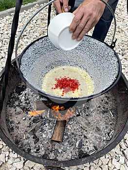 Cooking goulash in cauldron, outside, in a campsite