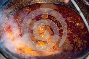 Cooking Goulash, seasoned spicy stew of meat and vegetables