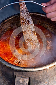 Cooking Goulash, seasoned spicy stew of meat and vegetables