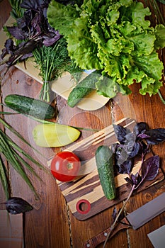 Cooking green  salad from organic vegetables around wooden table. flat lay