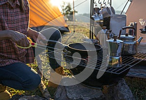 cooking and grill equipment and coffee maker on camp fire with tent and nature background