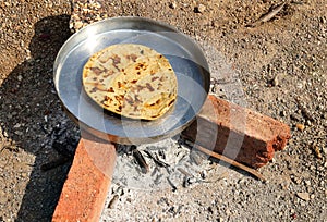 cooking in Gujarati village traditional sorghum ki roti or pearl millet flat bread. farmer\'s lunch which are bajre ki roti.