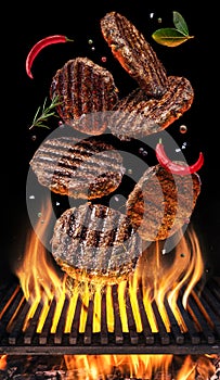 Cooking Hamburger cutlet. Conceptual picture. Steak with spices and cutlery under burning grill grate