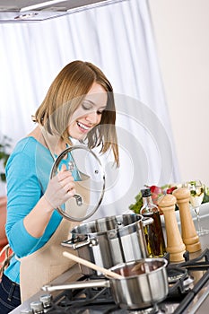 Cooking - Happy woman by stove in kitchen