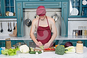 Cooking healthy and tasty food. Bearded man enjoy cooking natural food. Sexy naked chef cook prepare veggies for cooking