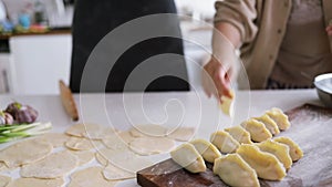 Cooking homemade dumplings, chinese dumplings with meat on a wooden table and ingredients for cooking.