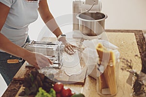 Cooking homemade noodles by a woman in the kitchen using a dough mixer and noodle cutter