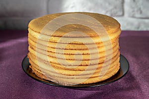 Cooking honey cake at home. Round baked cake layers stacked on a plate