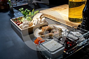 Cooking ingredient, lime, mushroom, shallot, lemon grass, onion, chilli, tobiko, bergamot, shrimp and cheese in wood box plate.