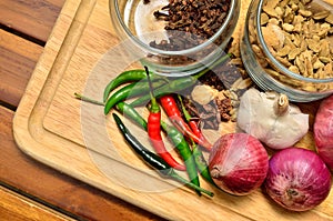 Cooking ingredients. Spice and herbs with onion and garlic on wooden board