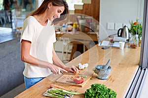 Cooking, kitchen and happy woman with healthy food, meal prep and cutting fresh vegetables for lunch. Diet, wellness and