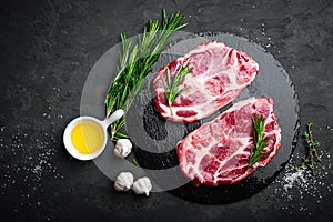 Cooking on kitchen table fresh raw pork marbled steaks on black background