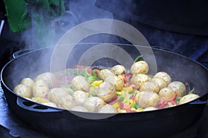 Cooking vegetables in large cast iron cauldron