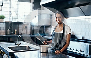 Cooking, making food and working as a chef in a commercial kitchen with tongs and industrial equipment. Portrait of a