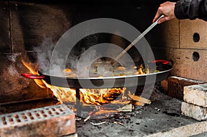 Cooking and making a traditional Spanish Paella over open fire