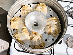 Cooking of Manty dumpling in metal steamer pot