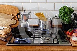 Cooking meal on a gas stove in traditional home kitchen. Wood worktop.