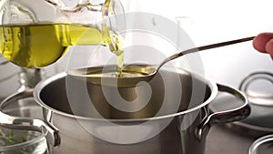 Cooking meal in a pot. Bottle of Extra virgin oil pouring in to pot for cooking meal.