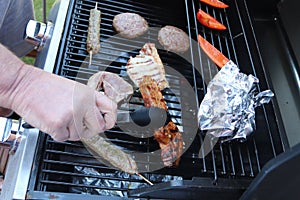 Cooking meat outdoors on a gas flamed bbq