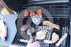 Cooking meat outdoors on a gas flamed bbq