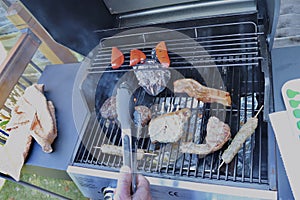 Cooking meat outdoors on a gas flamed bbq