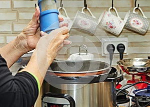 Cooking meat in a slow cooker, a woman peppers the meat